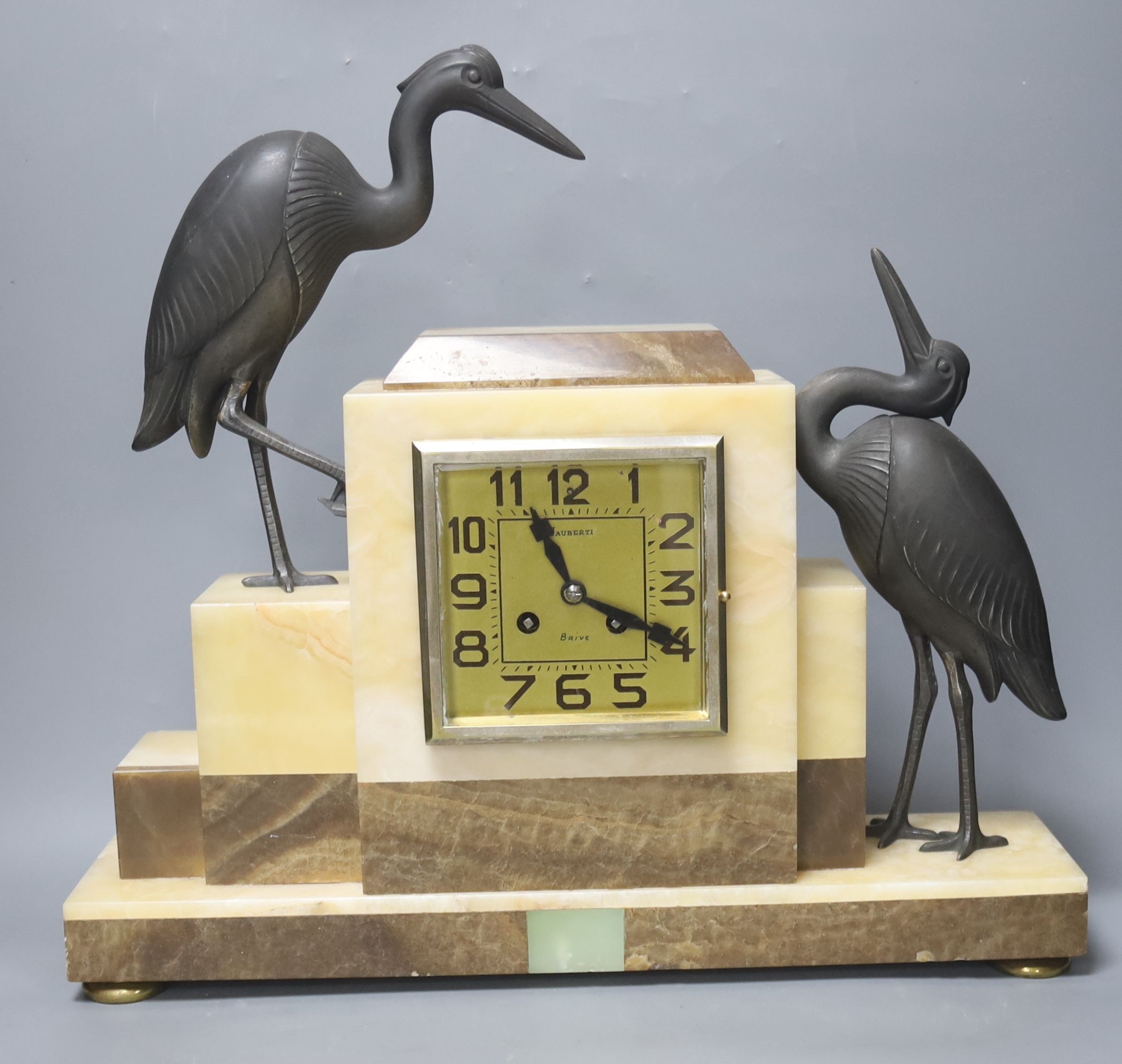 An Art Deco marble clock garniture clock surmounted with two spelter cranes, 42cm